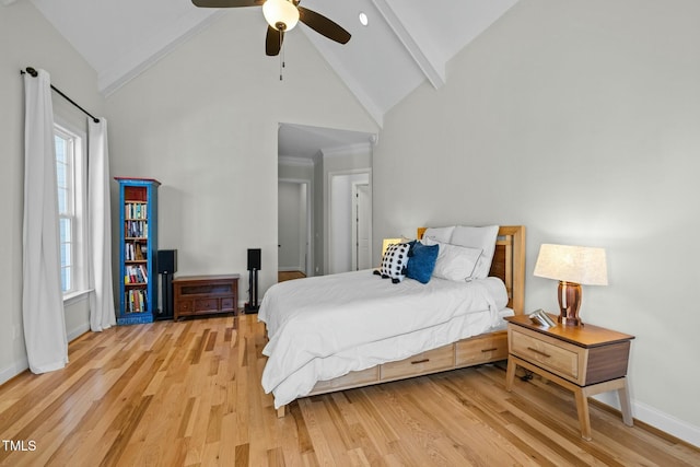 bedroom featuring light wood-style floors, baseboards, high vaulted ceiling, and beam ceiling