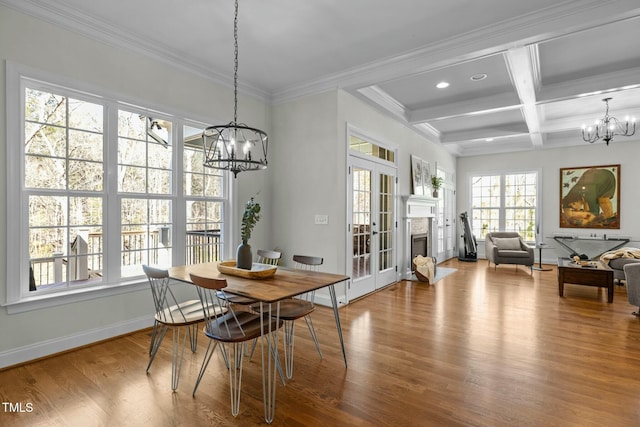 dining area featuring baseboards, coffered ceiling, wood finished floors, beamed ceiling, and an inviting chandelier