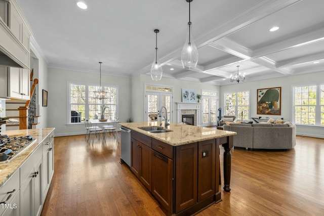 kitchen with stainless steel appliances, dark wood-type flooring, a sink, and an inviting chandelier