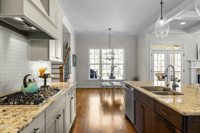 kitchen with custom exhaust hood, appliances with stainless steel finishes, a sink, and ornamental molding