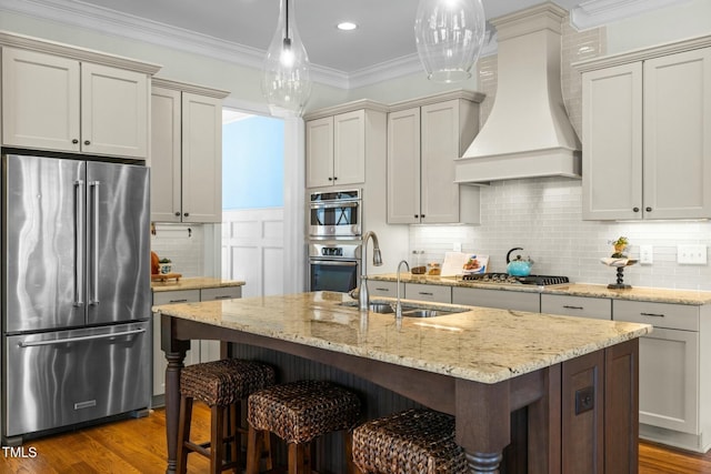 kitchen featuring crown molding, stainless steel appliances, decorative backsplash, a sink, and premium range hood