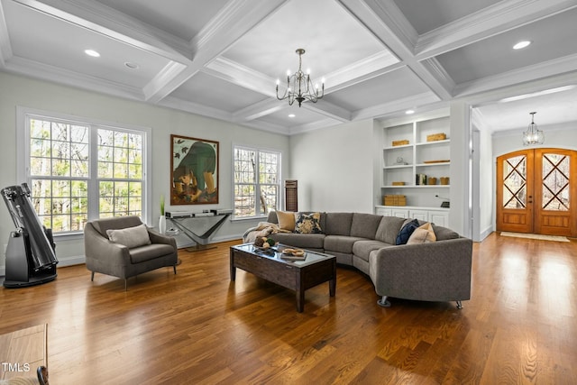 living room with beamed ceiling, wood finished floors, and a notable chandelier