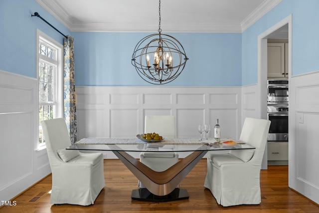 dining space featuring an inviting chandelier, breakfast area, dark wood-style flooring, and ornamental molding