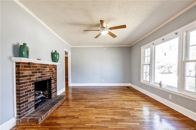 unfurnished living room with crown molding, a brick fireplace, a textured ceiling, and light wood-type flooring