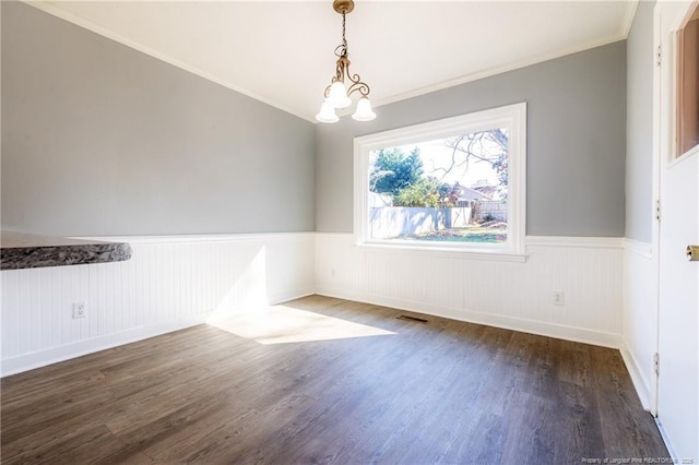 unfurnished dining area featuring a notable chandelier, crown molding, and dark hardwood / wood-style floors