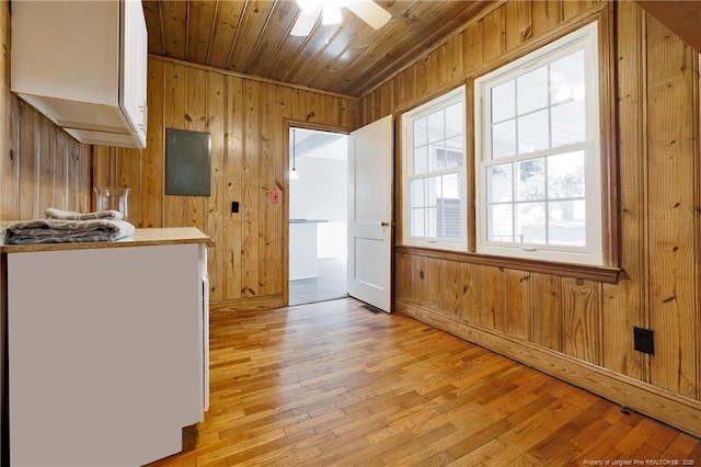 kitchen with wooden walls, wooden ceiling, ceiling fan, and light wood-type flooring