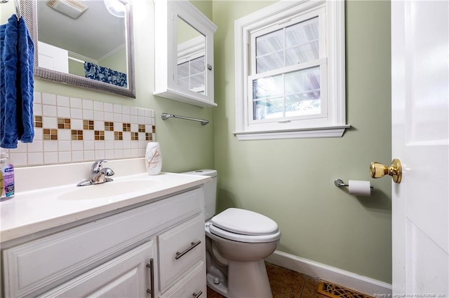 bathroom with tasteful backsplash, vanity, tile patterned floors, and toilet