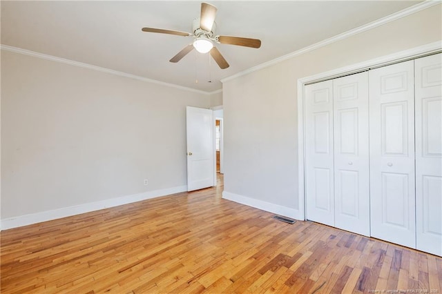 unfurnished bedroom featuring crown molding, a closet, ceiling fan, and light wood-type flooring