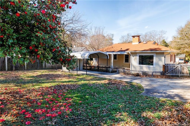 back of property with a yard and a carport