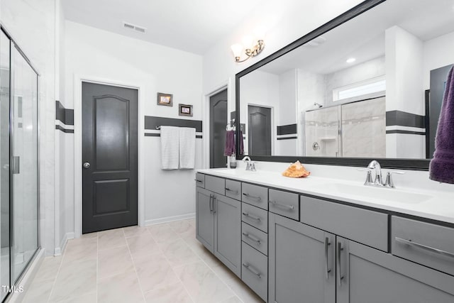 full bathroom with double vanity, a shower stall, visible vents, and a sink