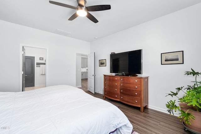 bedroom with ceiling fan, dark wood-type flooring, connected bathroom, and baseboards