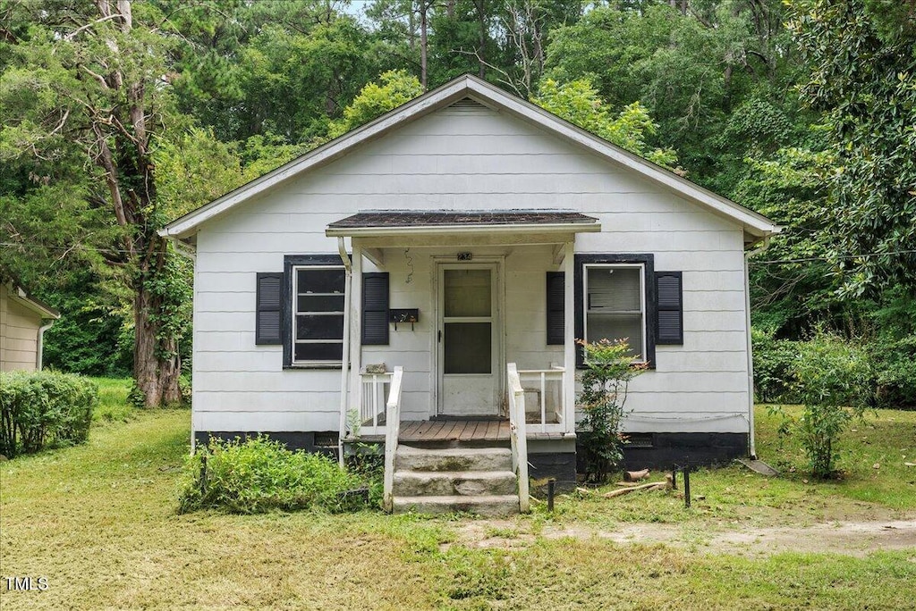 bungalow-style home with a front yard