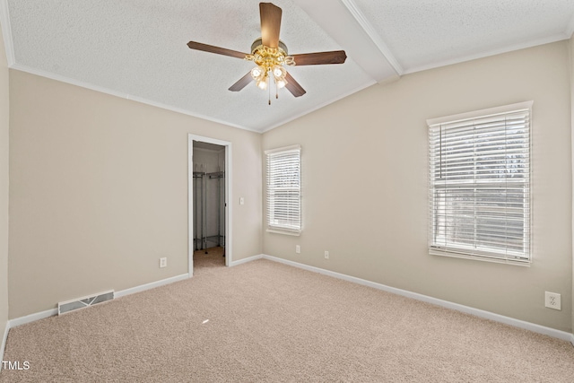 unfurnished bedroom with ceiling fan, vaulted ceiling with beams, carpet floors, a textured ceiling, and a spacious closet