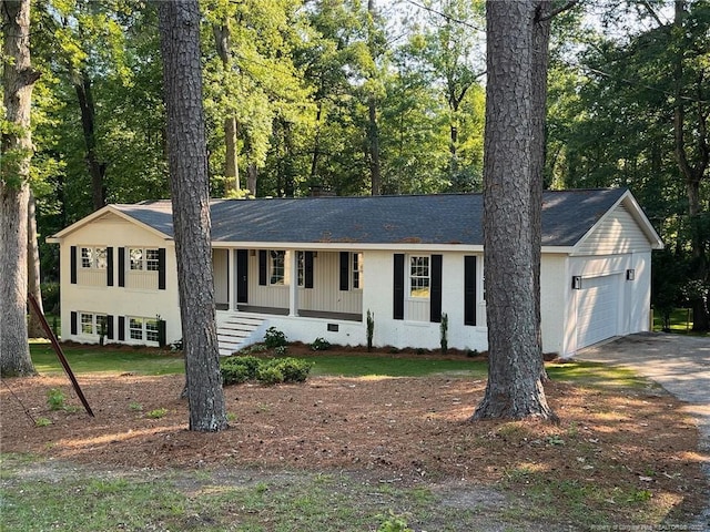 ranch-style house featuring a garage, covered porch, concrete driveway, and roof with shingles