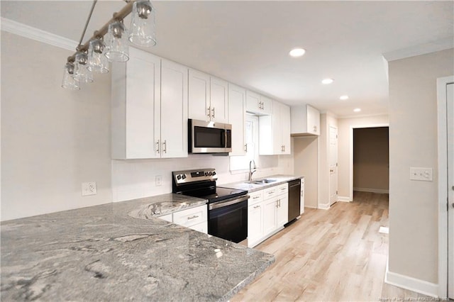 kitchen with appliances with stainless steel finishes, a sink, crown molding, light stone countertops, and white cabinetry