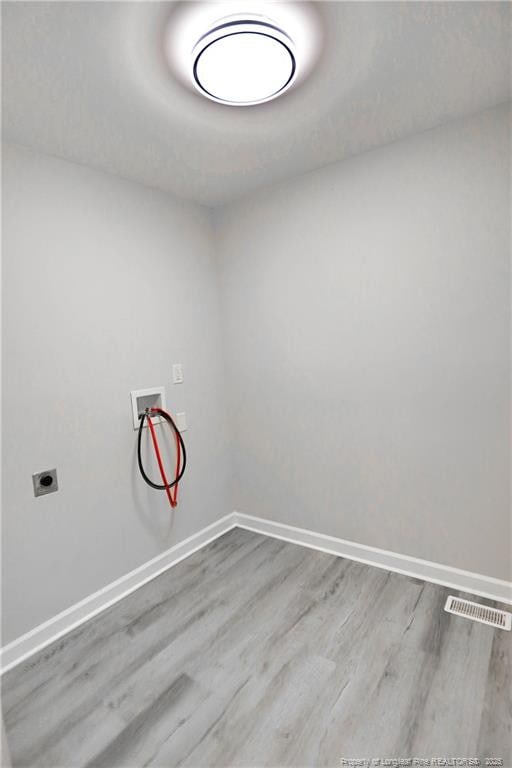 clothes washing area with hookup for a washing machine, baseboards, wood finished floors, and electric dryer hookup