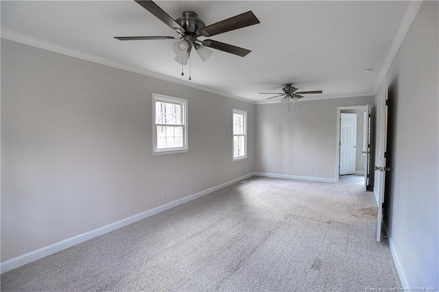spare room with ornamental molding, light carpet, baseboards, and a ceiling fan