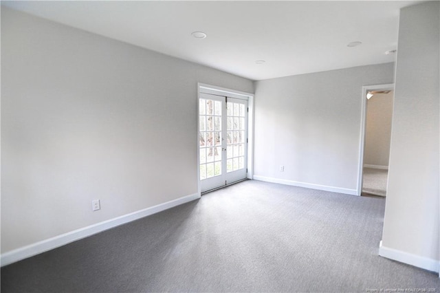 carpeted spare room featuring baseboards