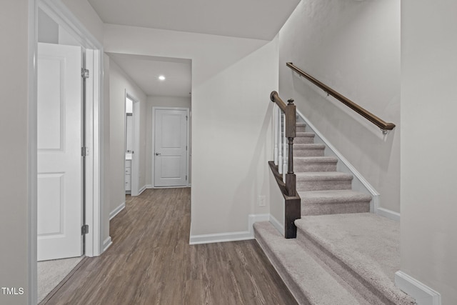 staircase featuring recessed lighting, wood finished floors, and baseboards