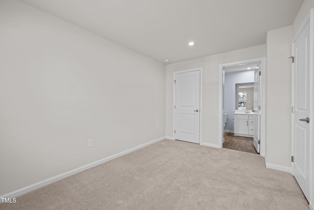 unfurnished bedroom with recessed lighting, baseboards, ensuite bathroom, and carpet
