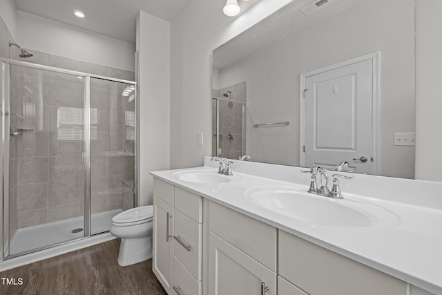 bathroom with toilet, a sink, visible vents, and a stall shower