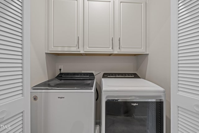 washroom featuring separate washer and dryer and cabinet space