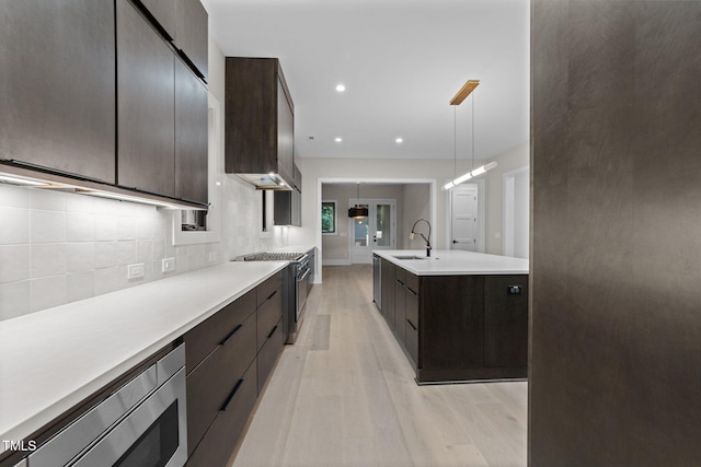 2305 Turners Aly, Raleigh, NC 27607 - kitchen featuring modern cabinets, light wood-type flooring, tasteful backsplash, light countertops, and appliances with stainless steel finishes