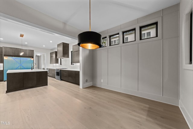 2305 Turners Aly, Raleigh, NC 27607 - kitchen with light countertops, modern cabinets, light wood-style flooring, stainless steel stove, and a decorative wall