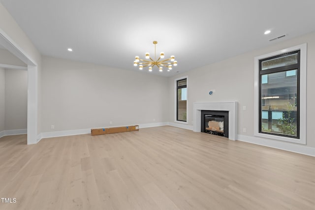 2305 Turners Aly, Raleigh, NC 27607 - unfurnished living room with light wood-style flooring, a chandelier, a glass covered fireplace, and recessed lighting