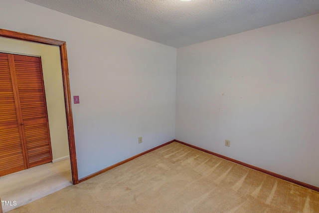 carpeted empty room with a textured ceiling