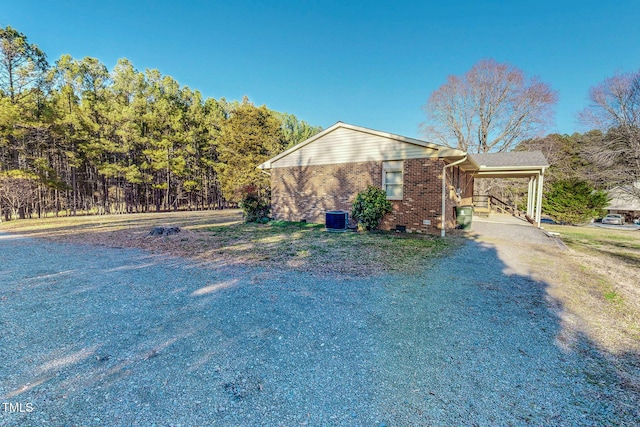 view of property exterior featuring central air condition unit and a carport