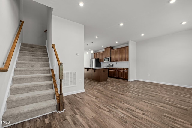 1414 Excelsior Grand Ave, Durham, NC 27713 - unfurnished living room featuring dark wood-type flooring, recessed lighting, stairs, and baseboards