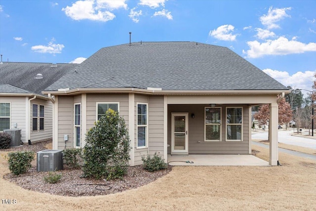 rear view of property with central AC, a shingled roof, and a patio area