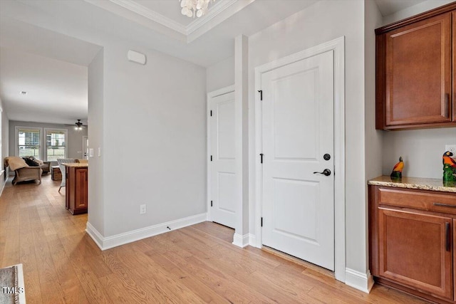 interior space featuring crown molding, light wood finished floors, an inviting chandelier, and baseboards