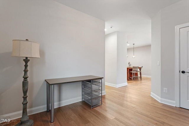 office area with baseboards and light wood finished floors