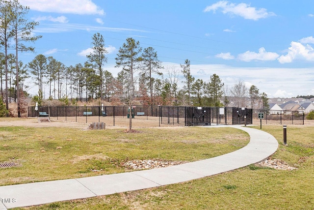 surrounding community with fence and a yard