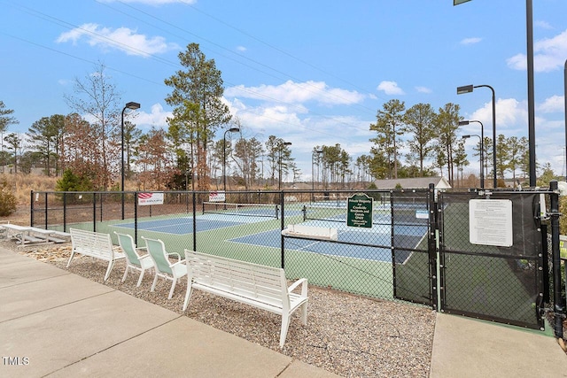 view of sport court featuring fence and a gate