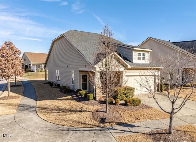 view of front of home with an attached garage, concrete driveway, and roof with shingles