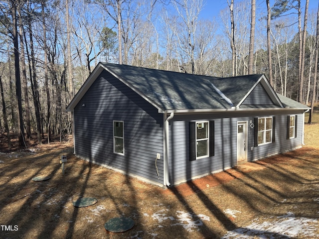 view of side of property with roof with shingles