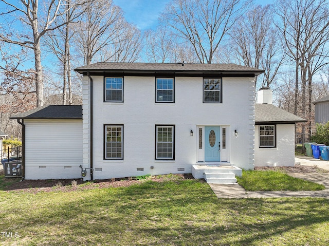 colonial inspired home with crawl space, a shingled roof, a front lawn, and brick siding