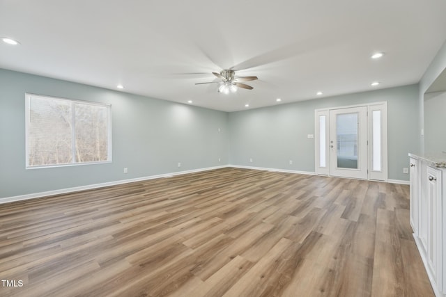 unfurnished living room with baseboards, light wood-style floors, and recessed lighting