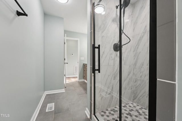 bathroom featuring a marble finish shower, visible vents, and baseboards