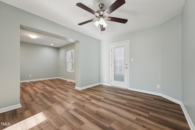 empty room with a ceiling fan, baseboards, and wood finished floors