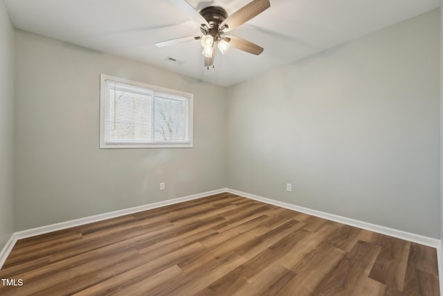 empty room featuring visible vents, wood finished floors, a ceiling fan, and baseboards