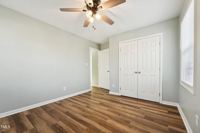 unfurnished bedroom with a ceiling fan, a closet, baseboards, and wood finished floors