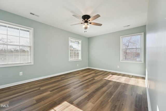 unfurnished room with a ceiling fan, visible vents, baseboards, and wood finished floors