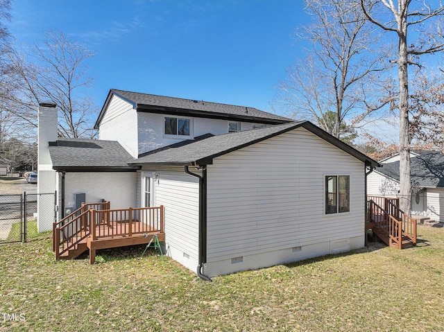 back of house featuring a shingled roof, a lawn, crawl space, fence, and a wooden deck