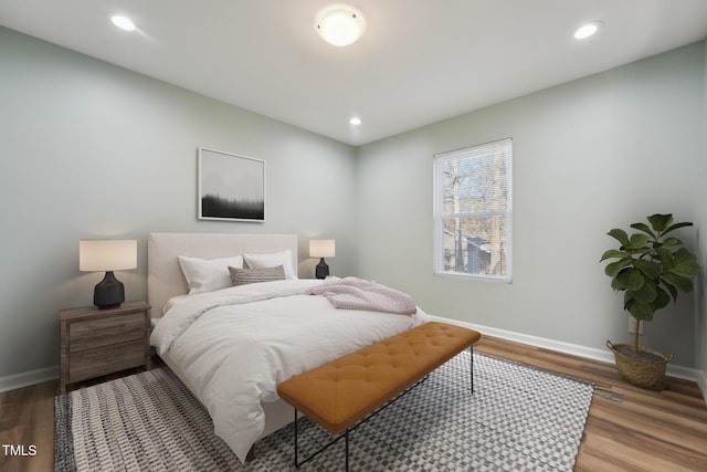 bedroom with baseboards, wood finished floors, and recessed lighting