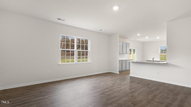139 Ethel Ln, Angier, NC 27501 - unfurnished living room featuring dark wood-style flooring, recessed lighting, baseboards, and a sink