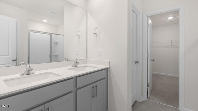 139 Ethel Ln, Angier, NC 27501 - full bath with double vanity, a shower with shower door, a spacious closet, baseboards, and tile patterned floors
